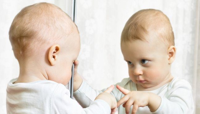 ребенок смотрит на зеркало
