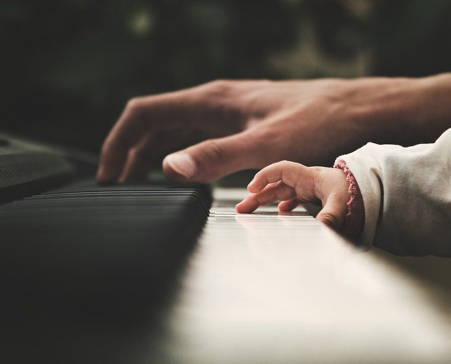 папа и сын играют на пианино